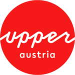 Logo Oberösterreich Tourismus: roter Kreis mit weißem upperaustria Schriftzug