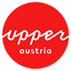 Logo Górna Austria Turystyka: czerwone kółko z białym napisem upperaustria